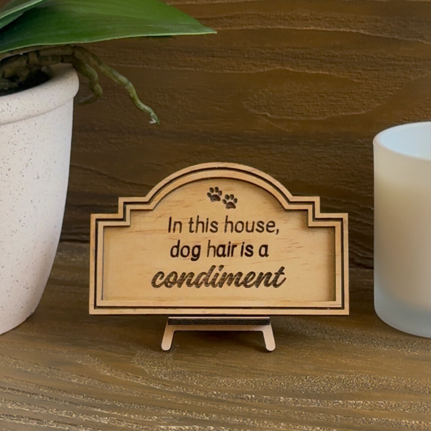 Cute Miniature Pine Plywood sign with easel stand featuring a laser engraved quote "In this House, dog hair is a Condiment" Approx 6cm High and 10cm Wide. 